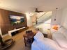 Wood-slat feature wall, wood-finish flooring, staircase with glass railing, and ceiling-mounted fan