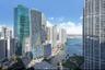 High-rise urban landscape featuring dense metropolitan architecture, waterway access, and waterfront green space