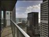 Private balcony featuring neutral tile flooring and a glass-paneled railing