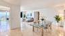 Open-concept living space featuring polished tile flooring, floor-to-ceiling glass sliding doors, and a private balcony
