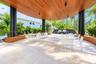 Covered outdoor terrace featuring a wood-paneled ceiling, stone tile flooring, structural cylindrical columns, and a built-in outdoor kitchen station 