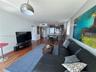 Open-concept interior featuring wood-finish flooring, a kitchen island, recessed lighting, and a brushed-metal dome pendant fixture