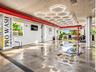Car wash and detailing station featuring custom hexagonal overhead lighting, industrial concrete flooring, and an integrated drainage system