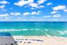 Elevated horizon with expansive ocean water, sandy shoreline, and clear skies