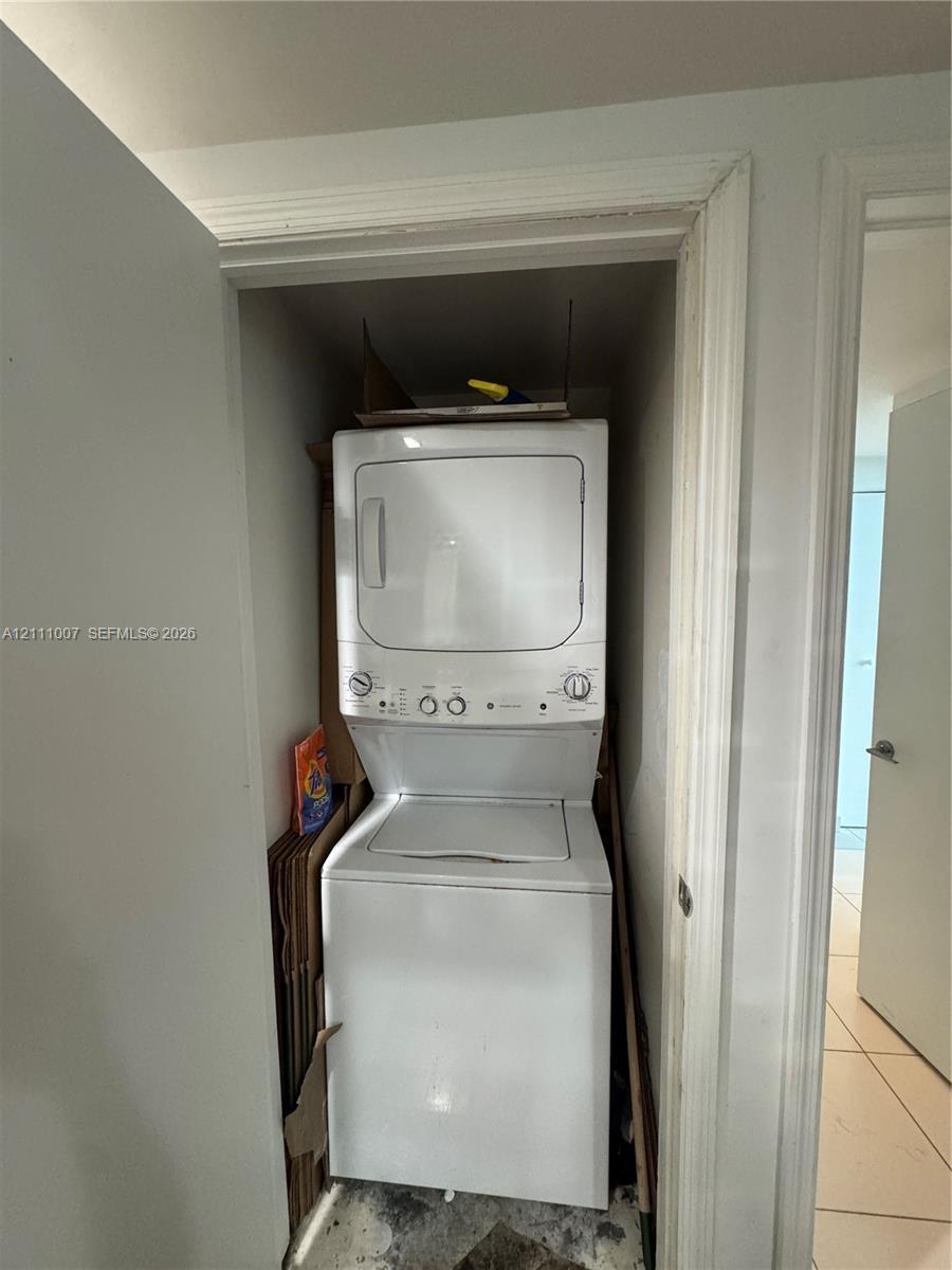 Stacked white laundry unit housed in a dedicated closet