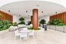 Covered outdoor terrace featuring large-format stone tile flooring, warm wood-paneled walls, integrated recessed lighting, and a central structural co