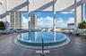 Rooftop terrace featuring a circular pool, tile decking, glass railing, and structural pillars