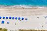 Direct oceanfront access featuring expansive sandy shoreline, turquoise water, and professional hardscaping
