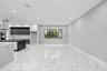 Open-concept interior featuring large-format polished stone-finish flooring, two-tone cabinetry with contrasting stone-finish countertops, stainless s