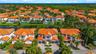 Aerial perspective featuring multi-story residences with terracotta-style tile roofing, paver driveways, and proximity to a canal