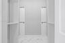 Storage space featuring white built-in shelving units, adjustable support tracks, and white stone-patterned flooring