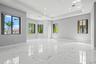 Spacious room featuring high-gloss large-format porcelain tile flooring, recessed ceiling lighting, a tray ceiling, and multiple windows