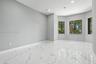 Polished tile flooring with marble-patterned veining, recessed lighting, and a bay window configuration