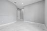 Interior space featuring polished large-format tile flooring with veining, curved wall architecture, and recessed ceiling lighting