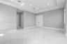Interior space featuring large-format tile flooring with marble-pattern veining, a recessed tray ceiling, recessed lighting, and double-door entry