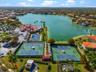Aerial view of community recreational facilities featuring multiple tennis courts, a basketball court, and immediate waterfront access