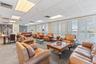 Open-concept interior space featuring a recessed coffered ceiling with integrated decorative chandelier lighting, geometric wood-finish flooring inlay