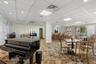Conference room featuring a drop ceiling with recessed lighting, wood-finish flooring with a central tile inlay, crown molding, chair rail trim, and w