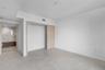 Neutral-toned tile flooring, light wood-finish sliding closet door, and crisp white wall palette