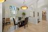 Polished stone flooring, arched windows with plantation shutters, vaulted ceilings, and a decorative multi-tier pendant light fixture