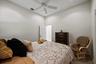 High ceilings, carpeted flooring, and a central ceiling fan with integrated light fixture