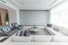 Textured wall covering in a blue-green hue, featuring a white floating console, three tiered white floating shelves, and a flush-mounted door with a m