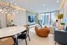 Open-concept interior featuring wood-finish paneling, recessed cove lighting, built-in cabinetry, a modern branch chandelier, and built-in stainless s