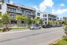 Modern multi-story residential building featuring private balconies, rooftop terraces, metal railings, and integrated spiral staircases