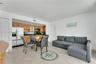 Kitchen featuring wood cabinetry, stainless steel refrigerator, and stone-finish countertops, paired with tile flooring throughout