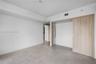 Neutral-toned ceramic tile flooring, clean-lined white walls, and a light wood-finish sliding door system