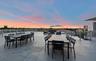 Expansive rooftop terrace featuring smooth concrete flooring and horizontal metal railings