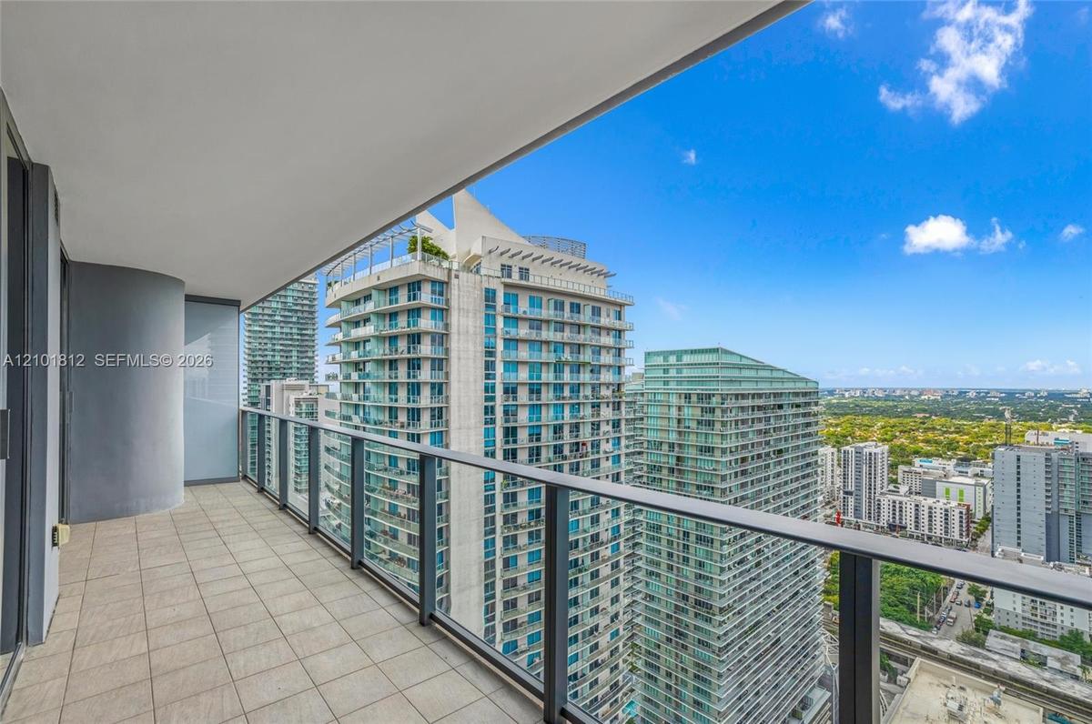 Private balcony featuring square tile flooring and a glass-paneled railing
