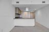 Kitchen featuring a peninsula with solid-surface countertop, wood-finish cabinetry, stainless steel island range hood, and tile flooring