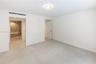 Neutral interior space featuring large-format light-toned tile flooring, minimalist white walls, recessed ceiling lighting, and solid-core interior do