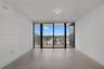 Floor-to-ceiling sliding glass doors, private balcony with metal railing, and neutral tile flooring