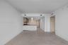 Open floor plan featuring tile flooring, neutral wall finishes, kitchen with wood-finish cabinetry, countertop breakfast bar, and stainless steel rang