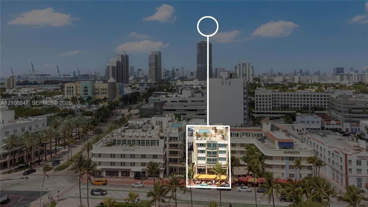 Aerial perspective featuring a multi-story building with a rooftop pool deck and prominent glass-facade balconies