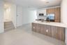 Kitchen featuring dual-tone cabinetry with wood-finish and matte white uppers, quartz countertops, a central island, stainless steel appliances, and l