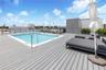 Rooftop terrace featuring composite decking, a built-in swimming pool with a metal handrail, perimeter metal railings, and a decorative patterned exte