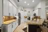 Kitchen featuring white cabinetry with matte black hardware, stone-finish countertops, tile backsplash, and recessed lighting
