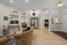 High ceilings featuring recessed lighting, polished stone flooring, built-in display niches, and an arched-top glass cabinet
