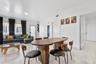 Open-concept interior featuring light-toned tile flooring, neutral wall finishes, and large windows