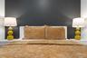 Contrasting charcoal-toned accent wall paired with a minimalist white headboard and built-in, side-mounted white cabinetry