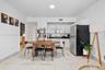 Kitchen featuring white high-gloss cabinetry, dark stone-surface countertops, and large-format tile flooring