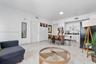 Open living area featuring large-format stone-style tile flooring, white cabinetry with contrasting black countertops, and recessed lighting