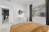 Neutral-toned ceramic tile flooring throughout, expansive horizontal window with integrated blinds, and smooth white wall finishes