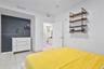 Room featuring large-format tile flooring, a charcoal accent wall, and wall-mounted industrial-style shelving