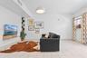 Neutral tile flooring, custom floating wood-finish media console, built-in corner display shelving, and modern dome pendant lighting