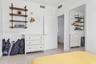 Wall-mounted industrial-style shelving with wood-finish planks, white tile flooring, and a floor-to-ceiling mirror