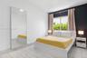 Full-height wall mirror, light-toned stone-finish tile flooring, and a bold dark accent wall